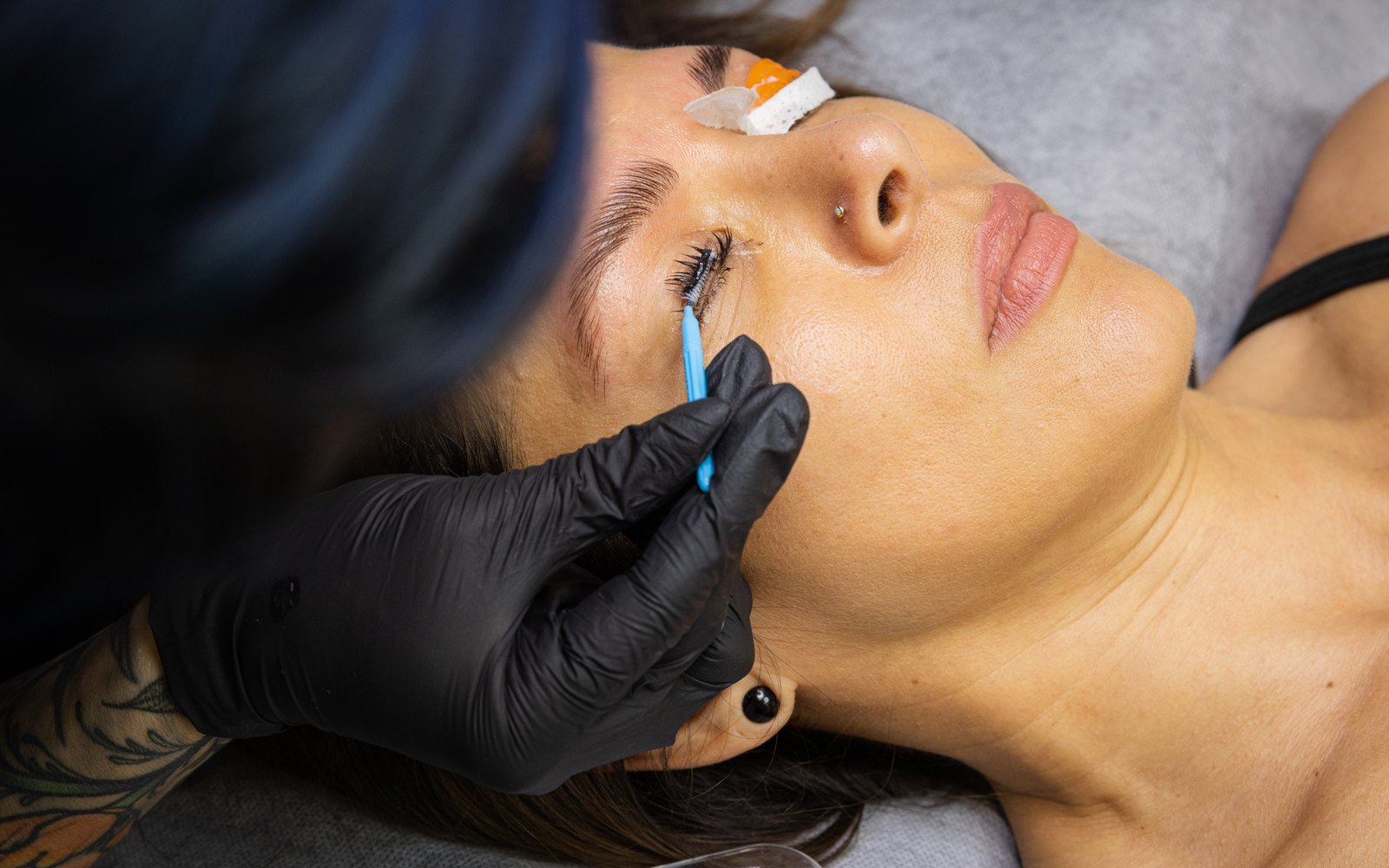 Freshly lifted lashes being combed out with a micro brush